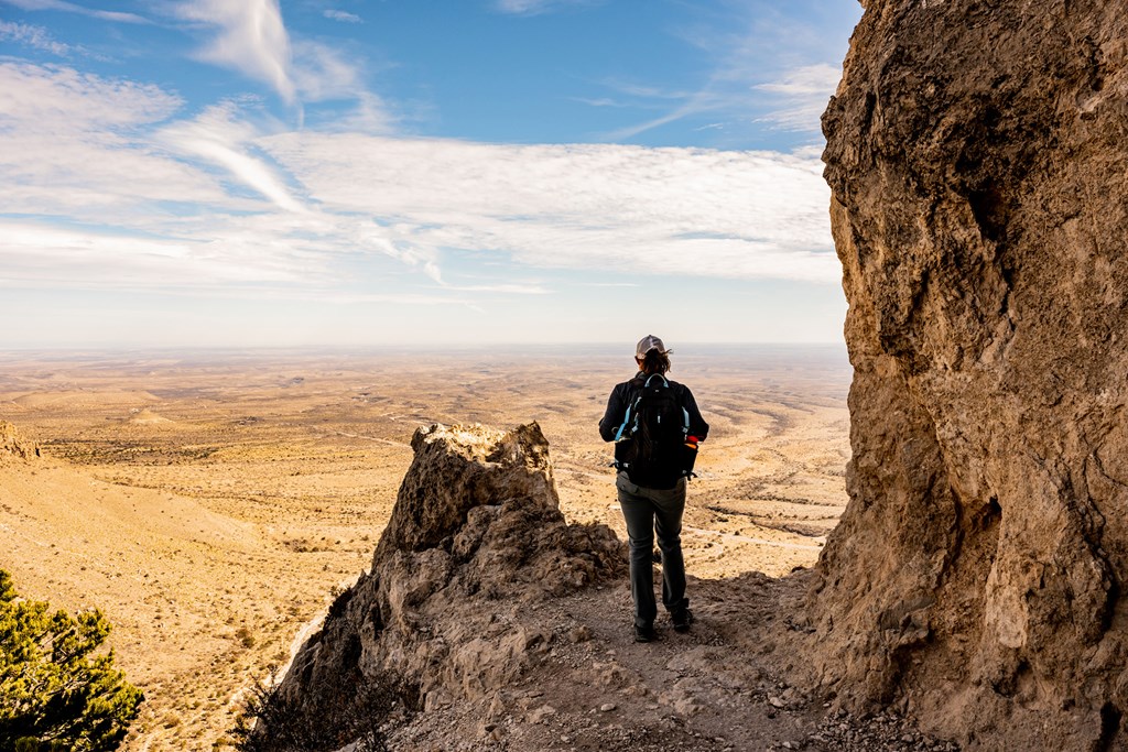 Woman Stands at Viewpoint Over Valley from Guadalupe Peak Trail