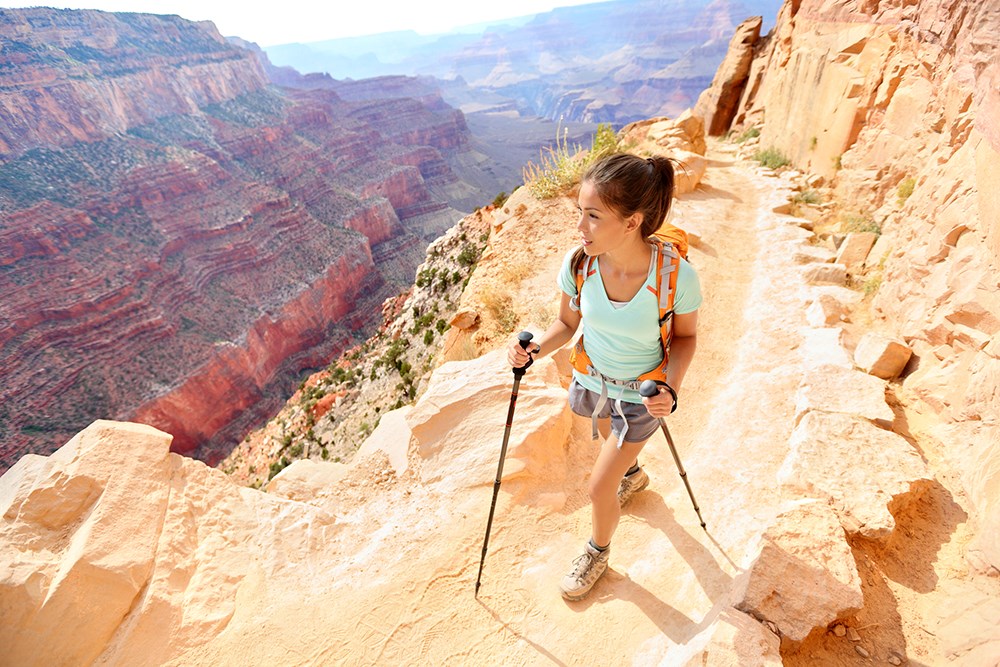 Hiker woman hiking in Grand Canyon walking with hiking poles. 