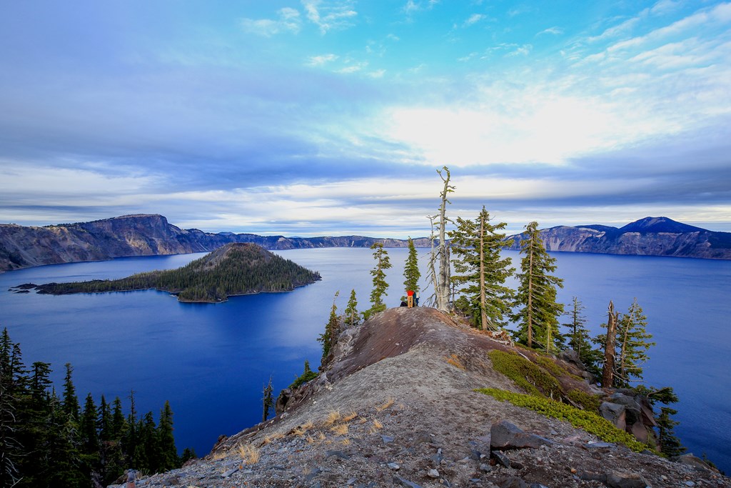 Two hikers overlook Crater Lake in Oregon.