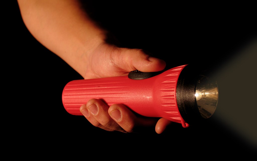 A person holding a red flashlight.