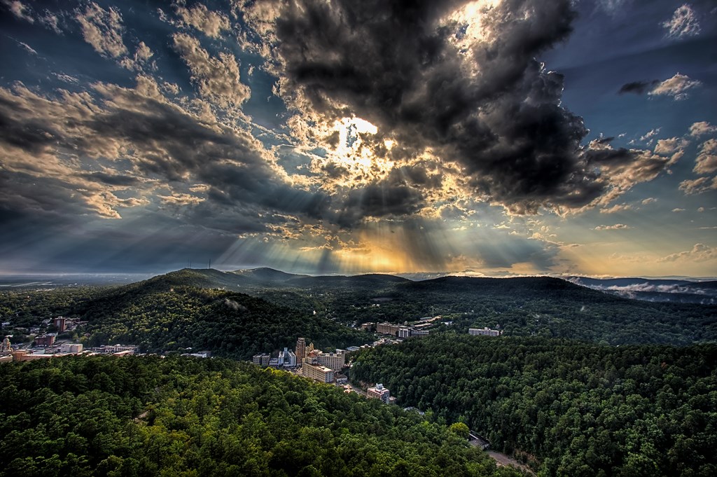 An aerial view of Hot Springs National Park in Arkansas with the sun peaking through the clouds.