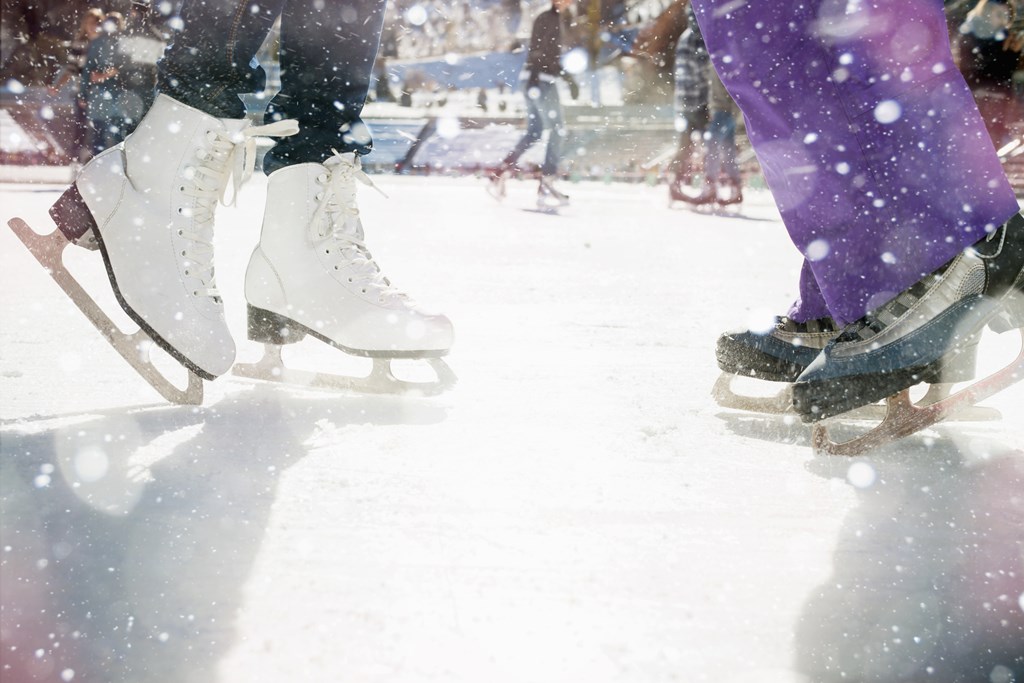 Closeup of two people ice skating.