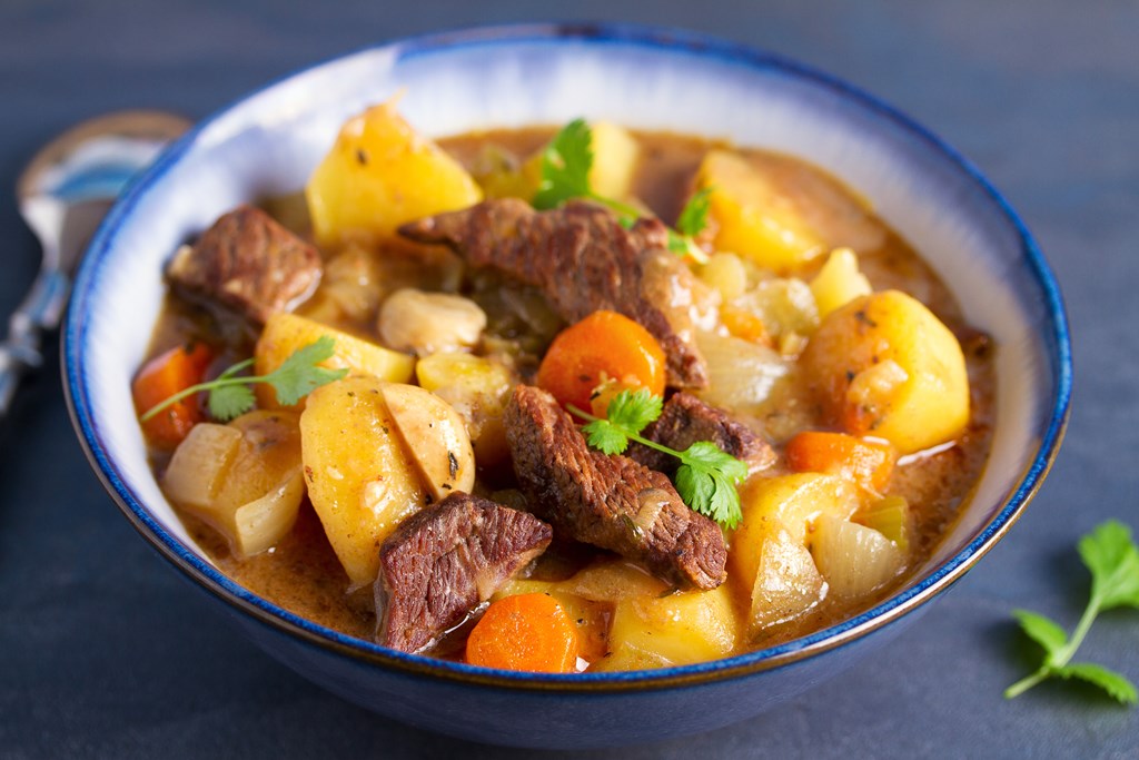 Closeup of a thick stew with beef, potatoes and vegetables.
