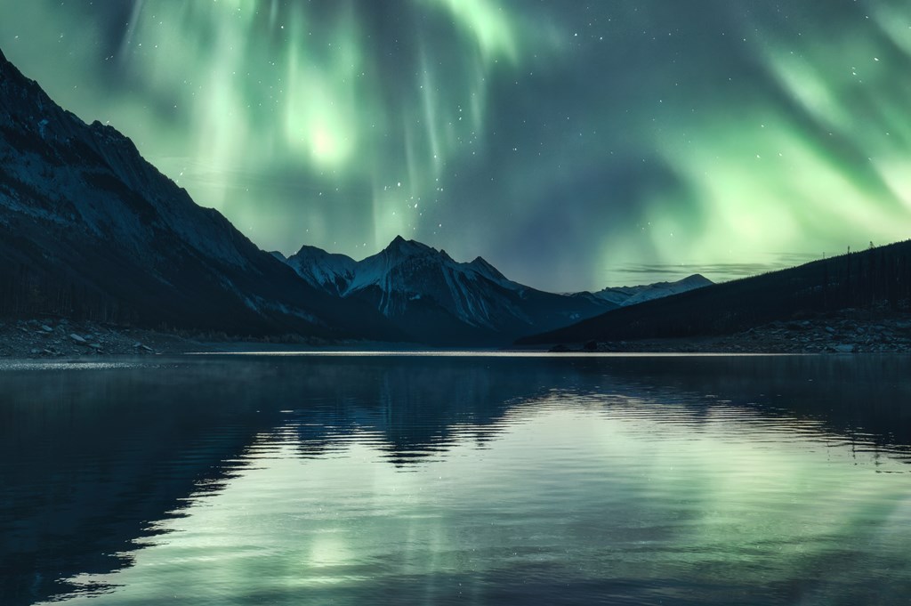 Beautiful scenery of Aurora borealis over Rocky Mountains in Medicine Lake at Jasper national park, AB, Canada.