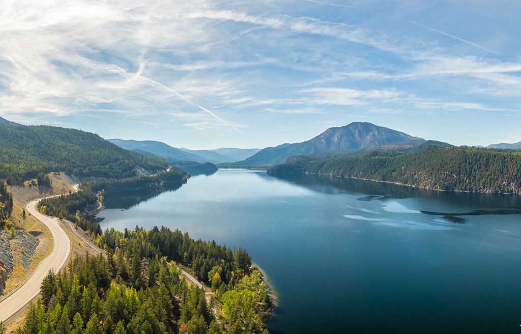 Aerial panoramic view of a scenic highway around mountains. East Kootenay, British Columbia, Canada.