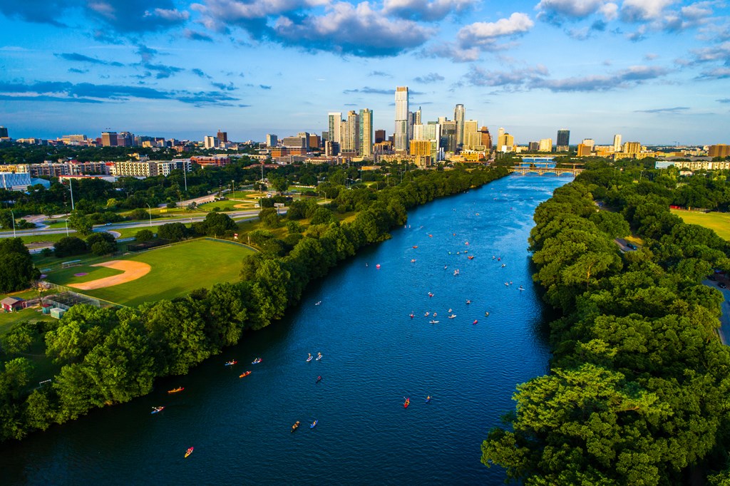 Aerial Drone view above Lady Bird Lake with kayakers and view of the city skyline.