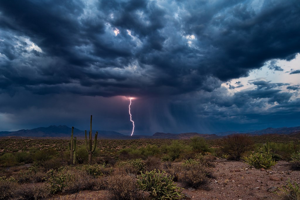 Thunderstorm with dark clouds and lightning over the Arizona desert.