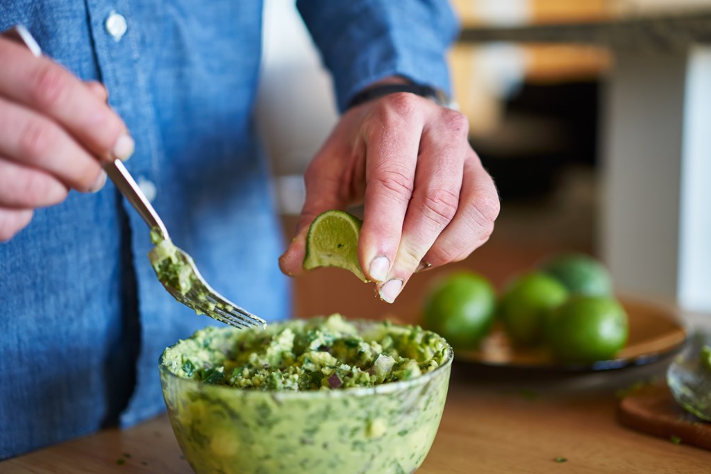 Close up of man making guacamole.