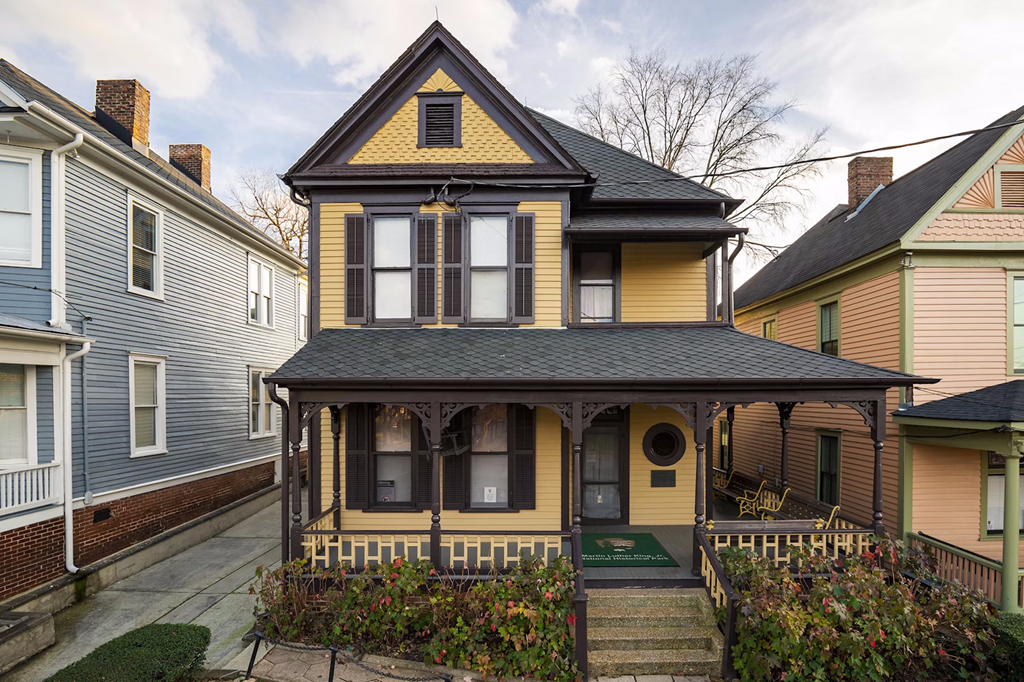 Exterior shot of Martin Luther King Jr.'s childhood home. A two story, yellow-sided house.
