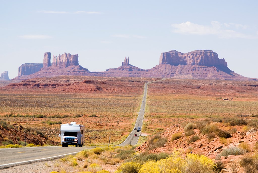 Recreational vehicle driving through Monument Valley.