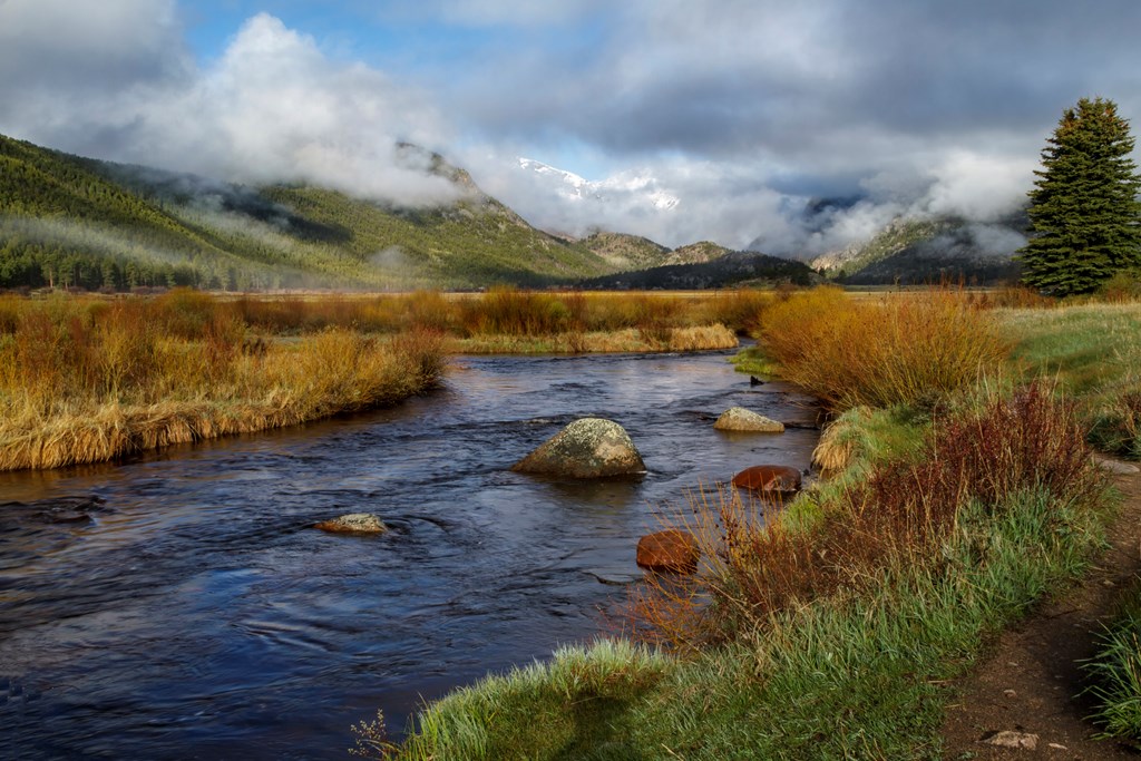 Clouds rolling in on Moraine Park in Rocky Mountain National Park with the Big Thompson flowing in the foreground.