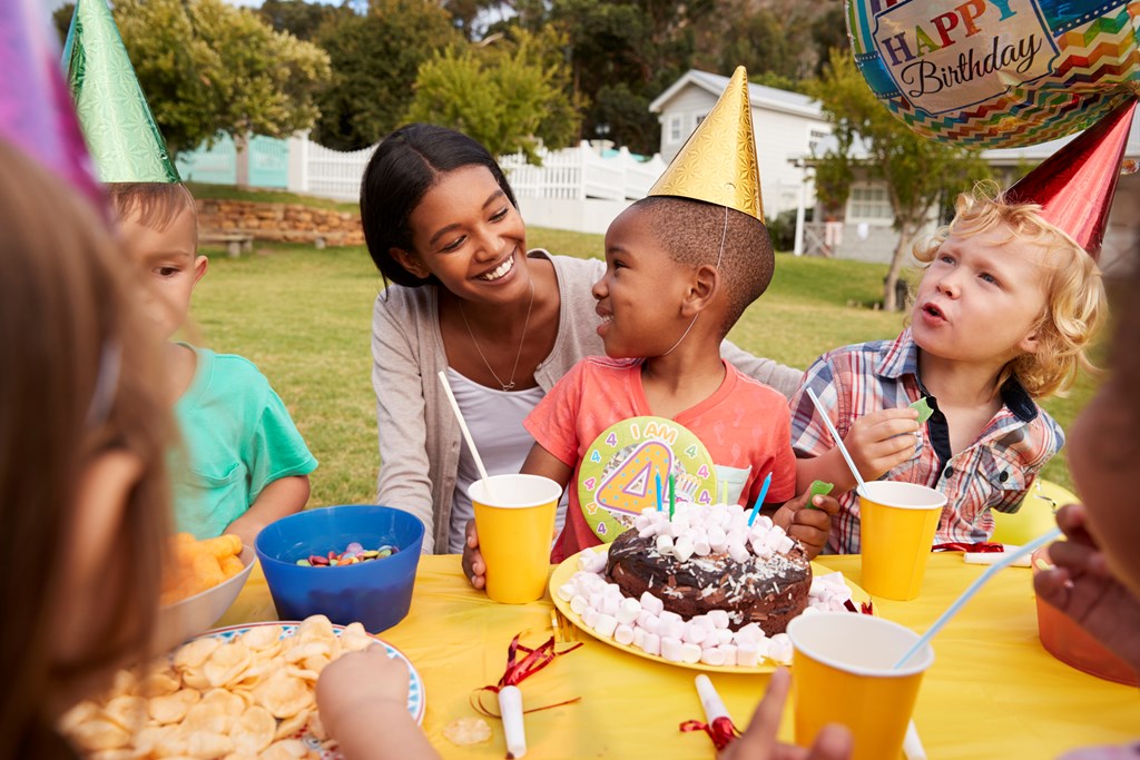 A mother has a moment with her young son during an outdoor birthday party.