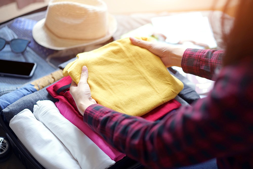 Woman pack clothes in for a trip.