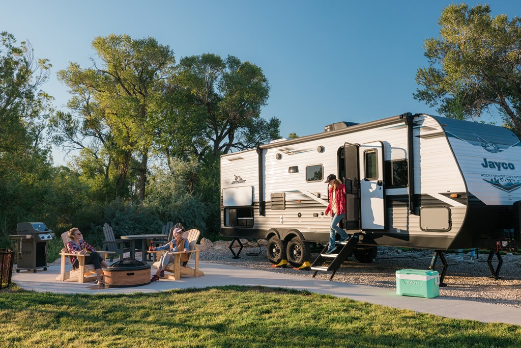 A family enjoys the campfire at their RV Site with KOA Patio.