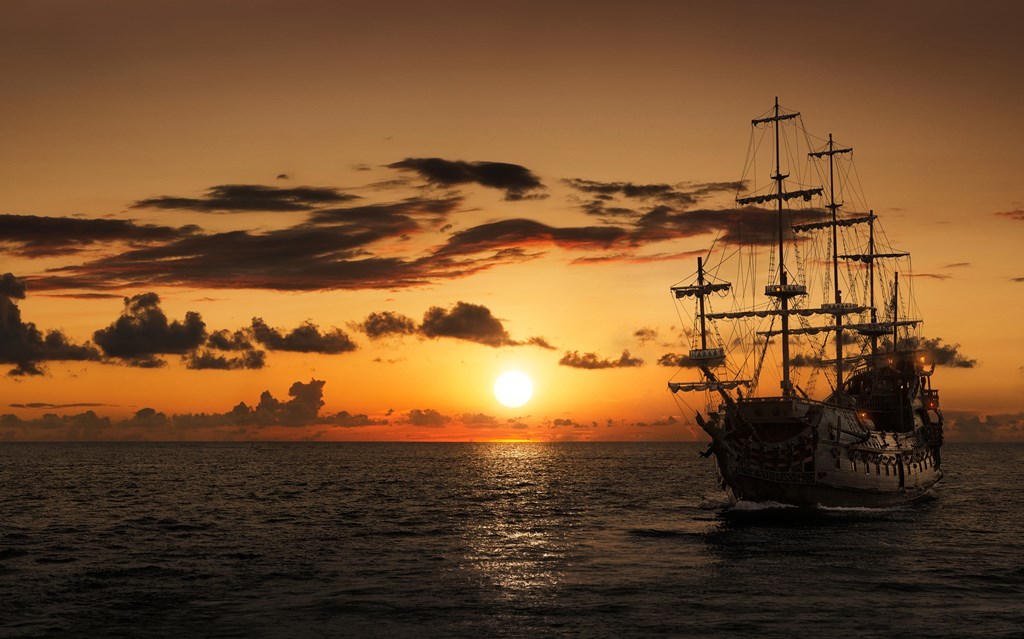 Silhouette of a pirate ship at sunset to set the scene for the Dem Bones scary short story for kids