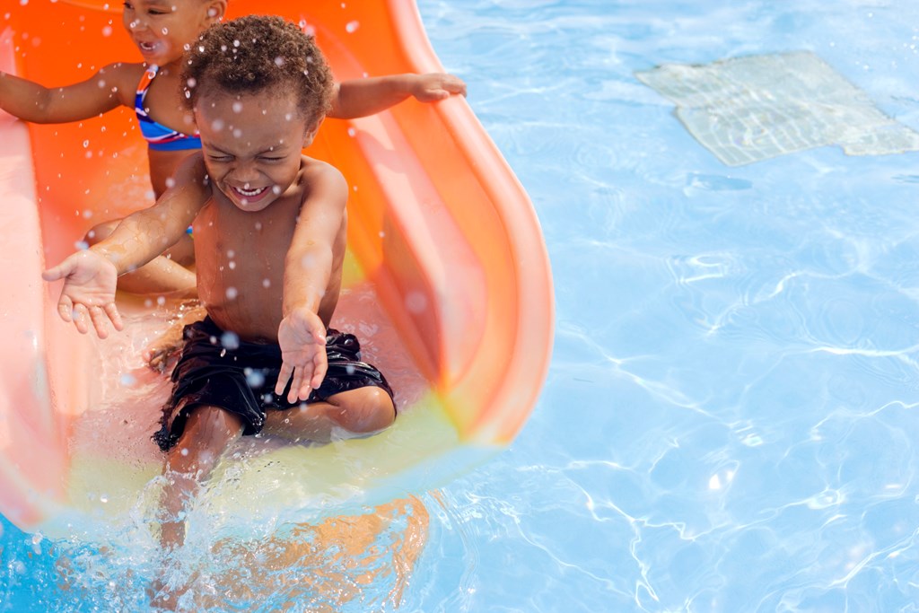 Kids enjoying the water slide at a water park in summer