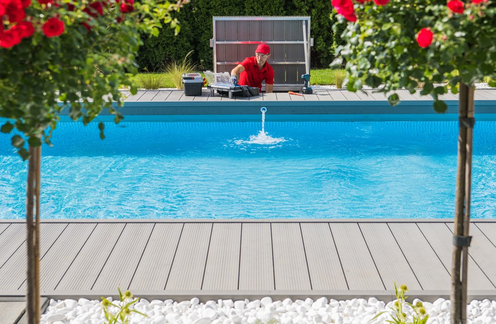 A pool technician works to ready a pool for summer.