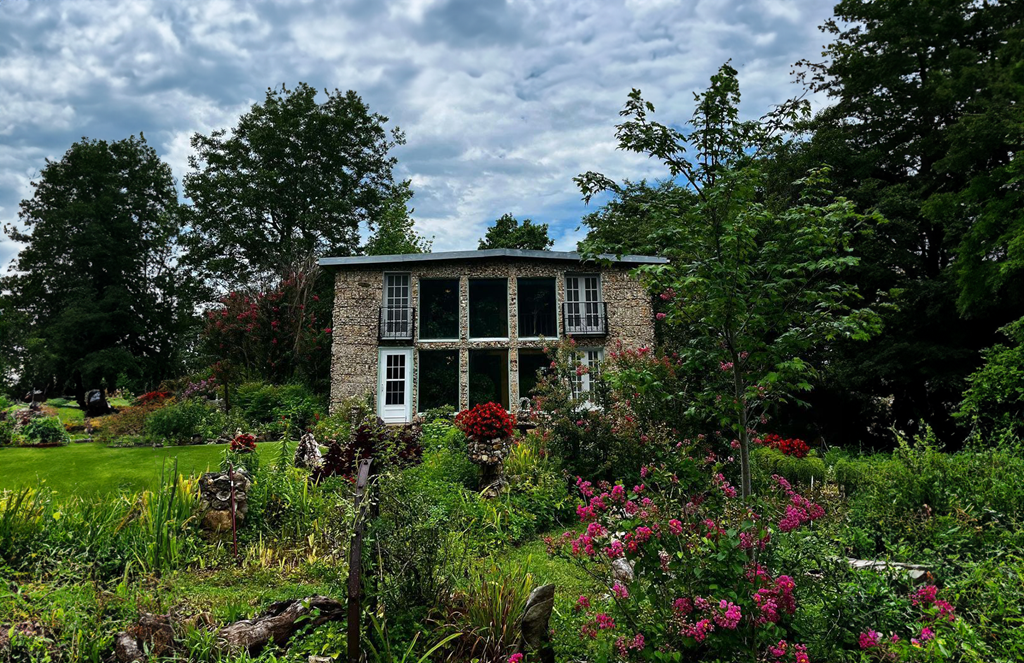 A stone house in a lush garden.