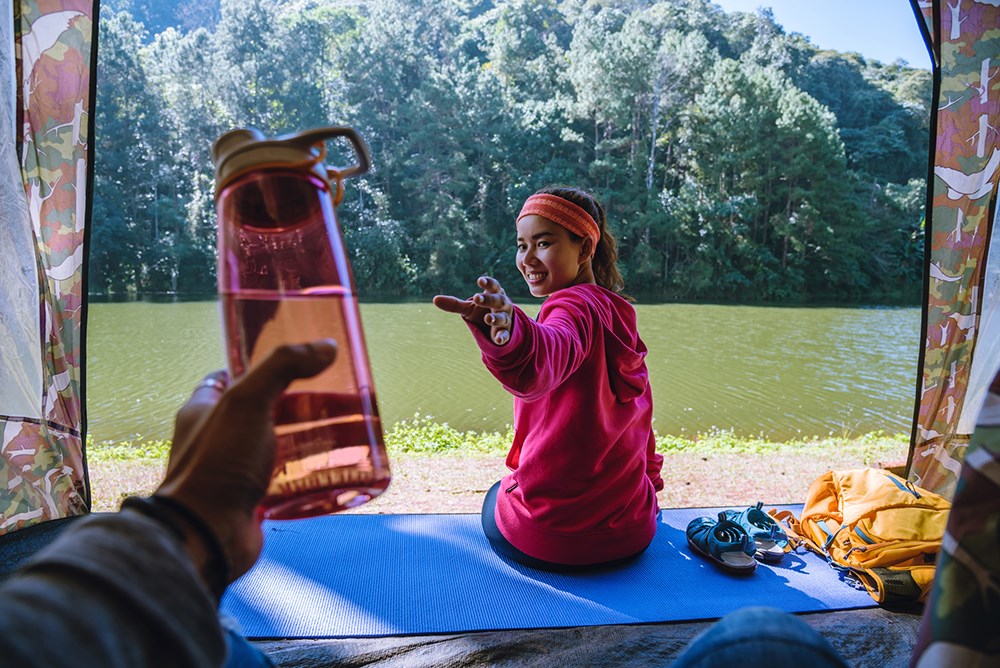 Couple handing reuseable water bottle.