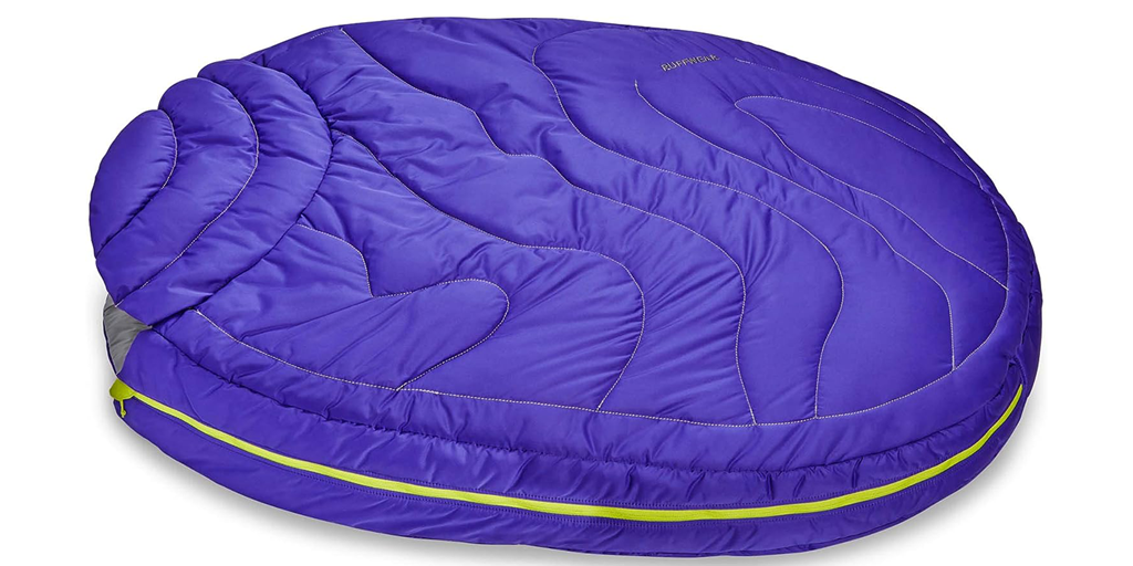 An outdoor dog bed made from a sleeping bag material.