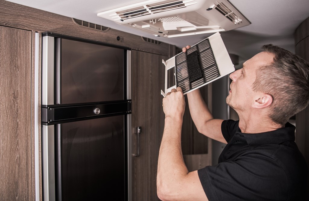 Man checking the air filter for his RV air conditioning.