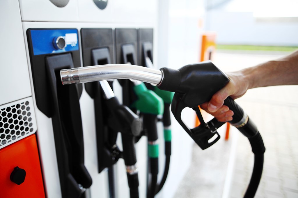 Detail of a hand holding a fuel pump at a station