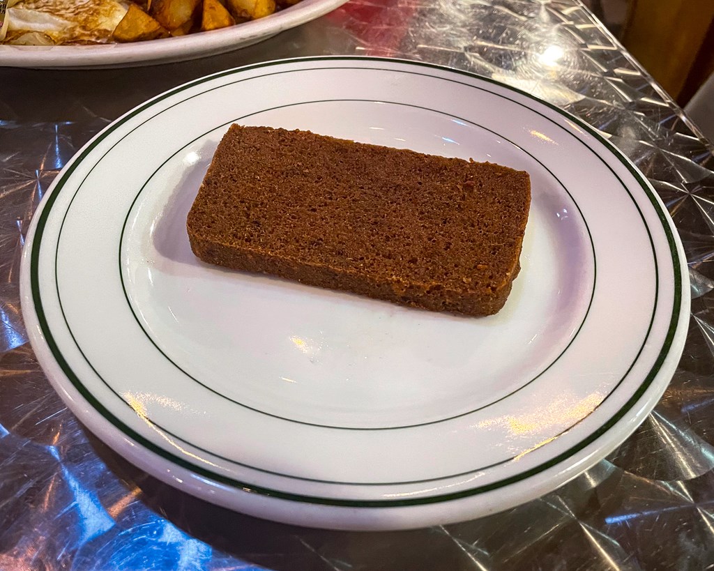 Scrapple, a pork-loaf dish, on a plate.