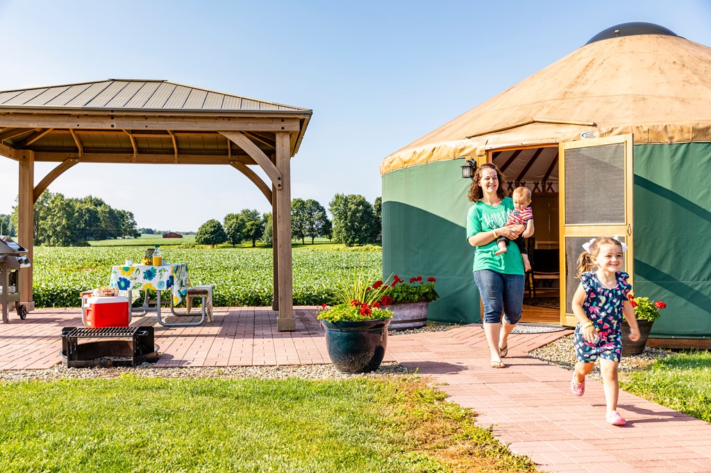 A young family leaves a yurt at a KOA campground.