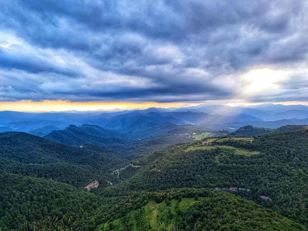 The mountains of Shenandoah National Park under a cloudy sky with rays of sunlight peeking through.