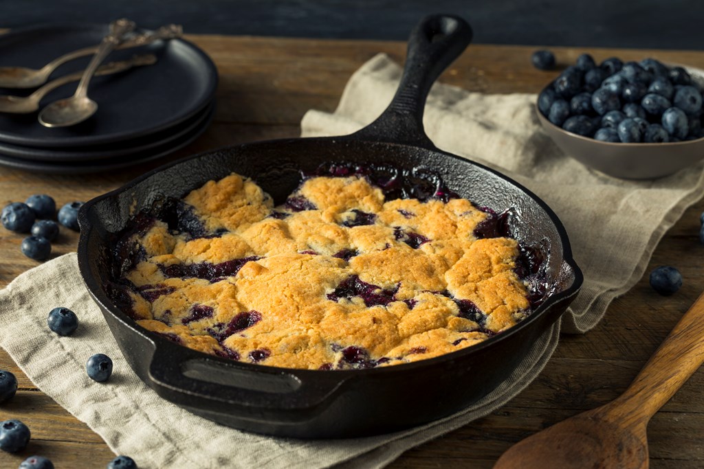 Blueberry cobbler dessert in a cast iron skillet.