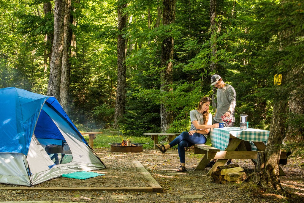 A couple sitting outside their tent.