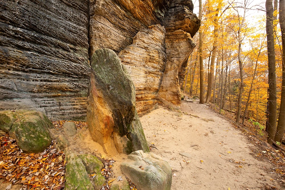Sedimentary rock outcrop of the Ritchie Ledges along a hiking trail in Cuyahoga Valley National Park near Cleveland, Ohio, in late autumn.