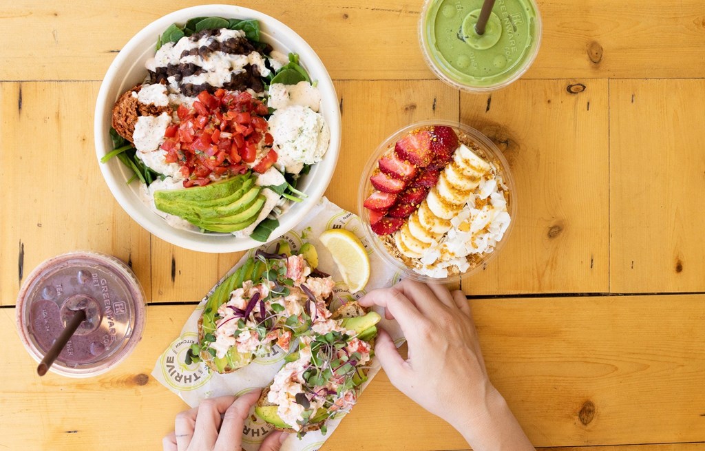 Top down view of healthy foods and juices on a wooden table.