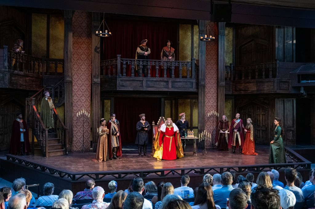A play on a stage with characters dressed in medieval dress.