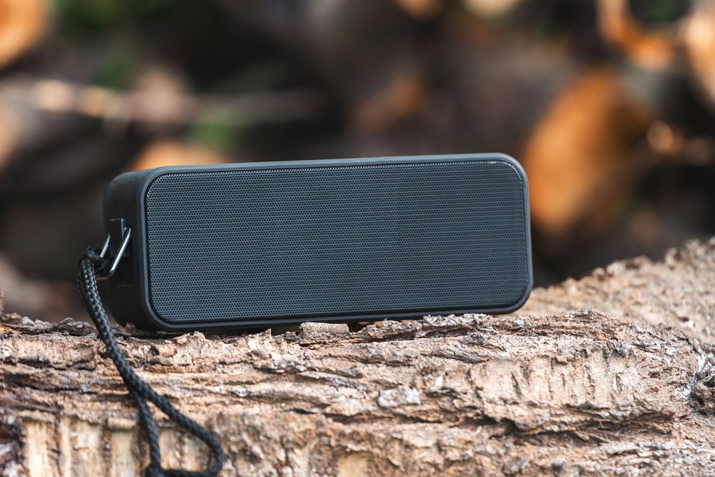 Portable wireless speaker for listening to music on a log.