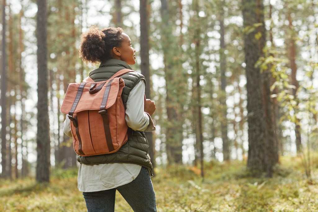 A young woman looking into the distance on a solo hike.