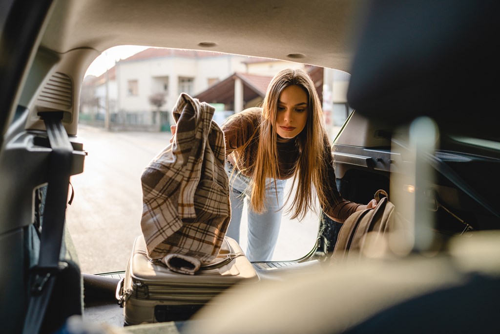 Woman packs the back of a car for a road trip.