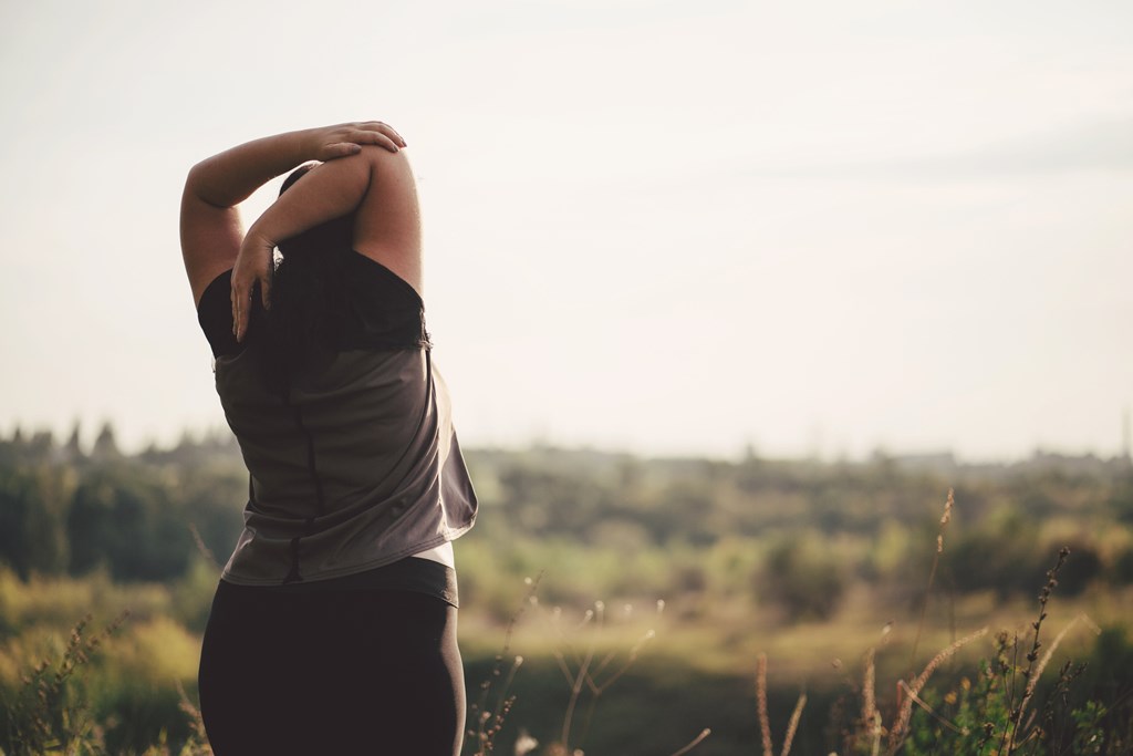 Woman stretching hands relaxing while walking outdoors. 