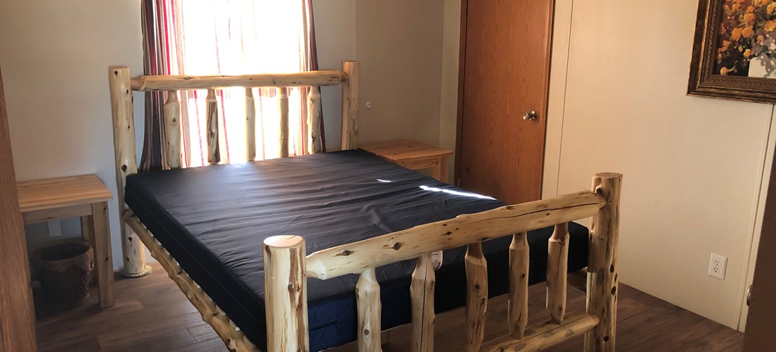 Bunkhouse master bedroom with log queen bed