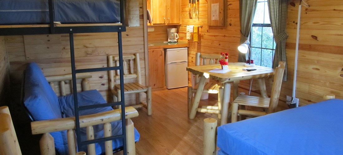 Deluxe Cabin-Park Model Interior with Cable TV, Kitchenette, Queen-size bed and Bunk Bed with Single on Top and Futon which opens to Full on Bottom (M01)