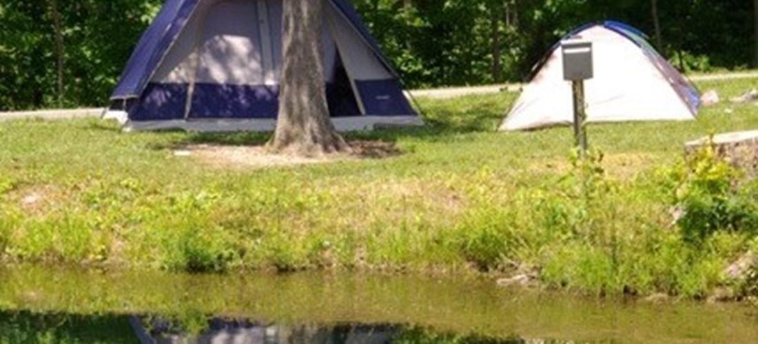 nice little camp site with a side perfect for you larger tent next to a small fishing pond