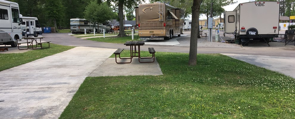 SITE 34 IS AN EXAMPLE OF ONE OF OUR FULL HOOKUP PULL-THRU SITES FEATURING A CONCRETE SLAB WITH PATIO WITH PICNIC TABLE, GRASS YARD, WATER, SEWER, 50/30/20 AMP ELECTRICITY, CABLE, AND WIRELESS INTERNET.