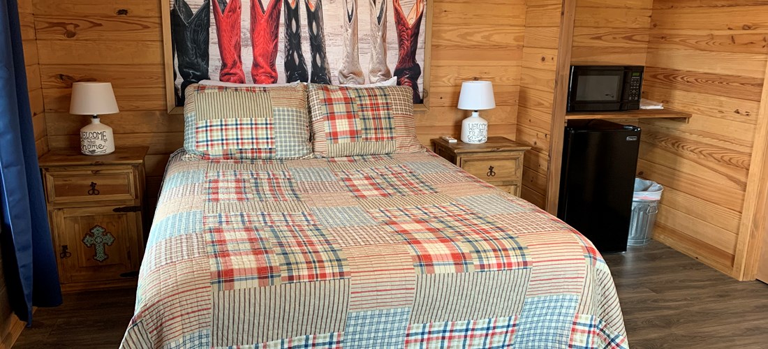 A queen size bed in one of our deluxe cabins