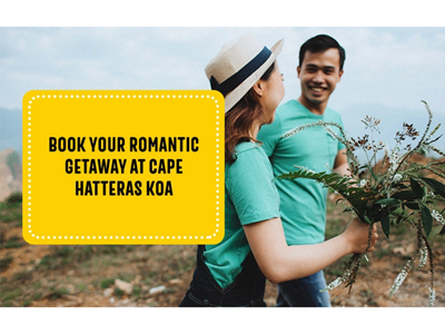 Couple walking along the Cape Hatteras shore and holding flowers from the landscape