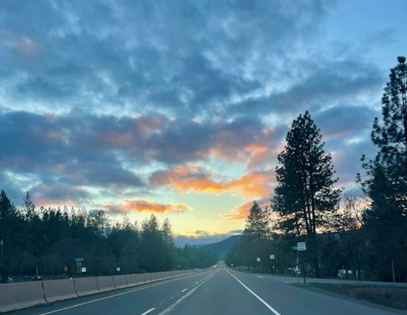The journey along Redwood Hwy is beautifully adorned with mountain views and fluffy clouds.