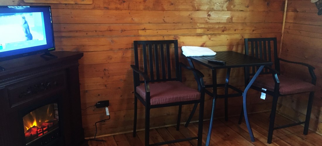 Inside Couple's Cabin Electric Fireplace & Bistro Set