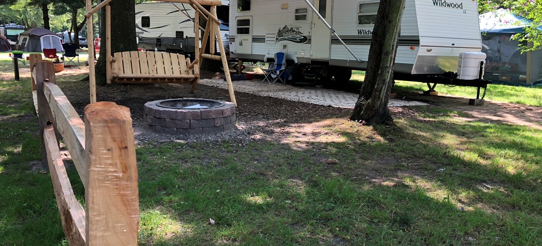 Premium Water & Electric RV site with rustic swing and enhanced fire ring.