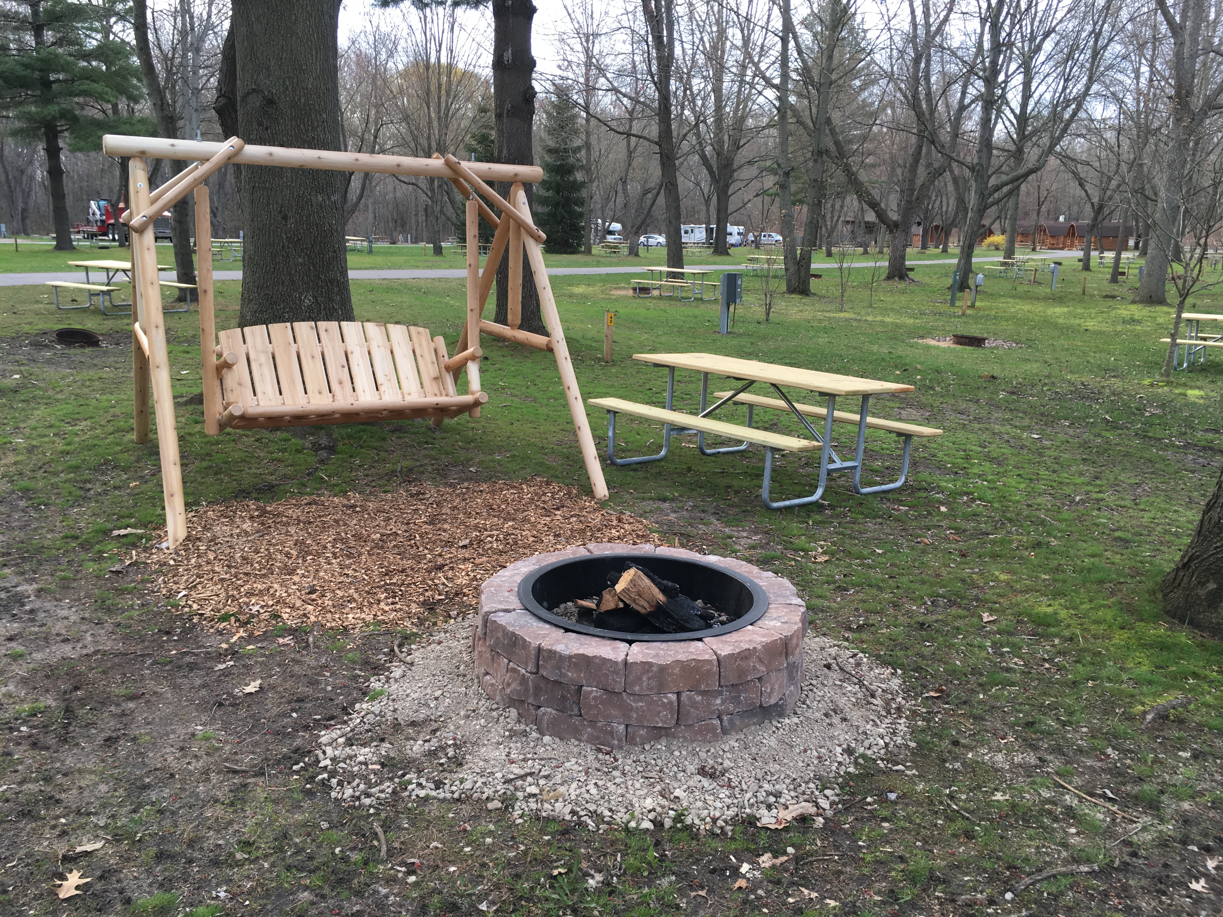 Premium Water & Electric RV site with rustic swing and enhanced fire ring.