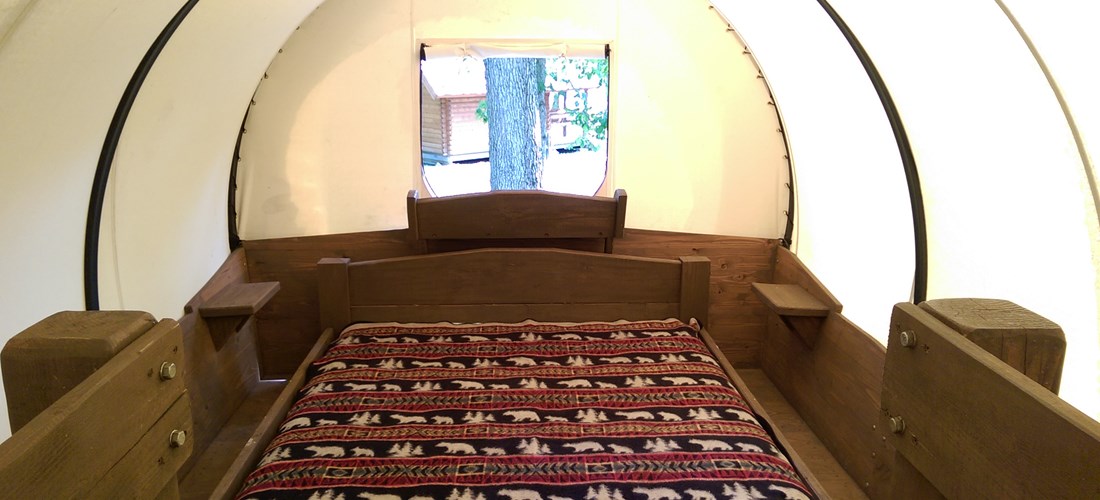 Snuggle down in a king-sized bed in the Conestoga wagon