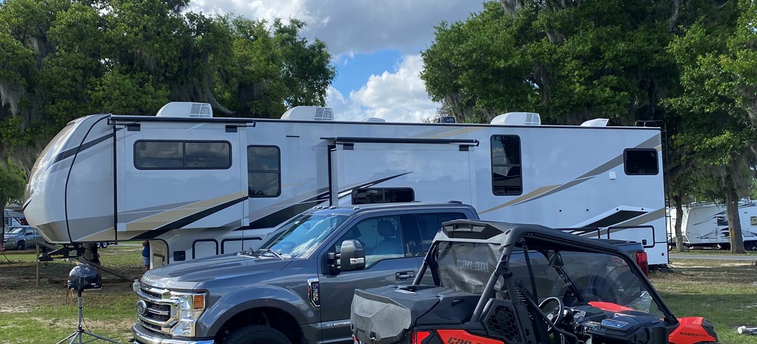 Side-By-Side parked next to a campers RV.  We allow you to park your off-road vehicles on your site!